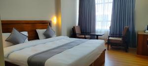 1 dormitorio con 1 cama grande, mesa y sillas en Hotel Gulmohar en Bharatpur