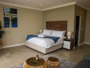 a bedroom with a large bed and a table at White Sands Self-catering units in Wilderness