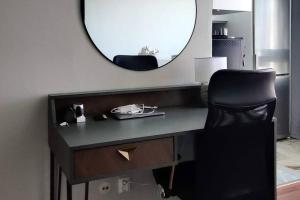 een bureau met een zwarte stoel en een spiegel bij City Center with Stunning Views in Stockholm