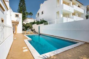 a swimming pool in front of a house at Villa Almanda - Spacious villa perfectly located between Albufeira Marina and the Old Town in Albufeira