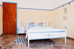 a bedroom with a white bed and a wooden door at Mavromati Rooms in Kivérion