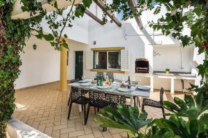 a patio with a table and chairs and a kitchen at Villa Almanda - Spacious villa perfectly located between Albufeira Marina and the Old Town in Albufeira