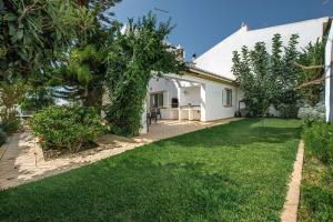 a white house with a yard with green grass at Villa Almanda - Spacious villa perfectly located between Albufeira Marina and the Old Town in Albufeira