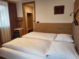 Penzion Tavcar في ليوبليانا: غرفة نوم بسريرين مع شراشف بيضاء