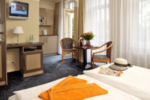 une chambre d'hôtel avec un lit et une table dans l'établissement Strandhotel Nordischer Hof, à Kühlungsborn