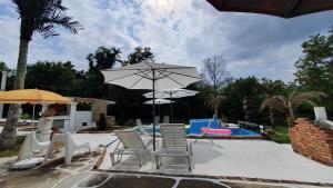 a patio with chairs and an umbrella and a pool at Spa center Apartment Belgrad in Brestovik