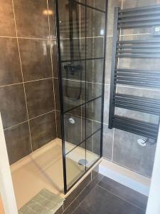 une douche avec une porte en verre dans une salle de bain dans l'établissement Mignon studio au cœur de Mèze, à Mèze