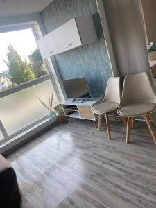 Cette chambre dispose de deux chaises, d'un bureau et d'une fenêtre. dans l'établissement Mignon studio au cœur de Mèze, à Mèze