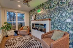 uma sala de estar com duas cadeiras e uma lareira em Lakefront Retreat~Hot Tub~Game Room~Fire Pit~ BBQ em Spirit Lake