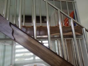 escalera de madera en una habitación con ventana en bucana traveler's inn, en Guinisiliban