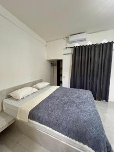 una camera con un grande letto e una finestra di Saellahouse a Gili Trawangan