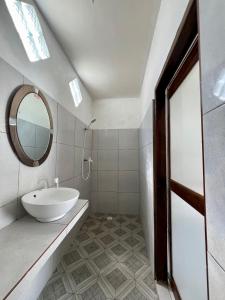 Baño blanco con lavabo y espejo en Saellahouse, en Gili Trawangan