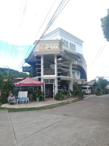 a building with a table and chairs in front of it at bucana traveler's inn in Guinisiliban