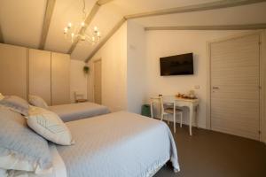 a bedroom with two beds and a table and a chandelier at Le Casette di Giò in Monteodorisio