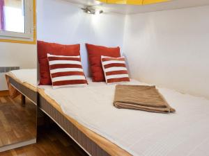 a bed in a room with red and white pillows at 3 pièces entre mer et nature - Les Clés de l'Esterel in Théoule-sur-Mer