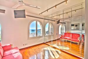 an empty living room with red furniture and windows at Club Villamar - Sereni in Sant Feliu de Guíxols