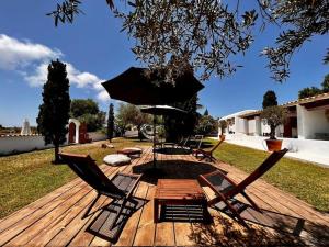een houten terras met stoelen, een tafel en een fontein bij Home / Rural Modern House in Sant Ferran de Ses Roques
