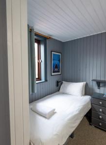 1 dormitorio con cama blanca y ventana en Insh Hall, en Kincraig