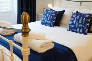 1 cama con mantas blancas y almohadas azules y blancas en Crescent View - Panoramic sea views, en Filey 6 fotos más