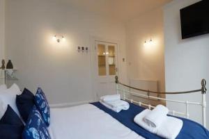 Un dormitorio con una cama y un televisor en la pared. en Crescent View - Panoramic sea views, en Filey