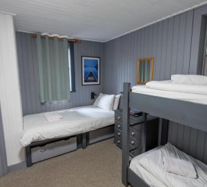 キンクレイグにあるInsh Hallのベッド2台と二段ベッド1組が備わる客室です。
