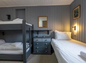 a bedroom with two bunk beds and a dresser at Insh Hall Rooms at Loch Insh in Kincraig