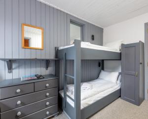a bedroom with bunk beds with a mirror and a dresser at Insh Hall in Kincraig