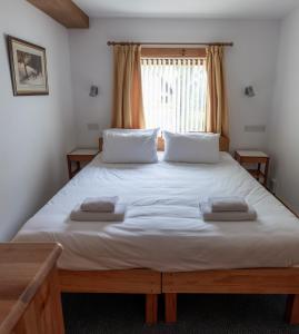 a bedroom with a large bed with two towels on it at Insh Hall in Kincraig