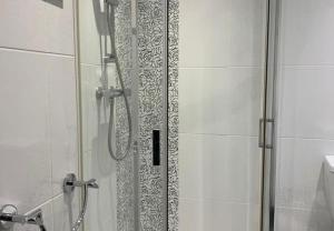una ducha con puerta de cristal en un baño en Apartment 2, 11 The Beach - Ground floor beachfront apartment - Ocholo Villas, en Filey 3 fotos más
