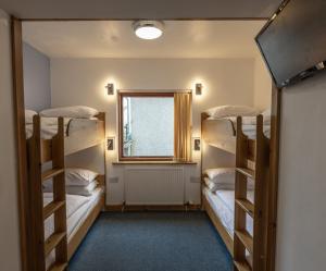 a room with three bunk beds and a window at Insh Hall in Kincraig