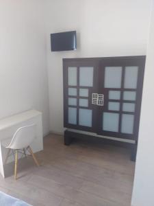 Habitación con escritorio, silla y TV. en Hostal Argo, en Barcelona