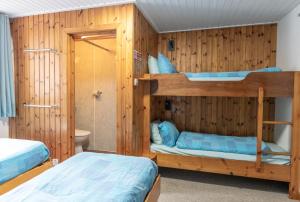 two bunk beds in a room with wooden walls at Insh Hall in Kincraig