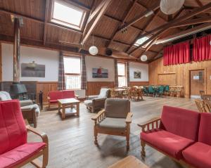 a large room with red chairs and tables at Insh Hall in Kincraig