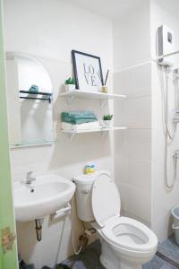 a bathroom with a toilet and a sink at Ezren Suites Mesavirre Residences Unit922 in Bacolod