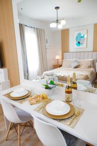uma mesa de jantar branca com 2 cadeiras e uma cama em Ezren Suites Mesavirre Residences Unit922 em Bacolod