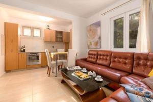 a living room with a brown leather couch and a table at Stancia Rosa - Apartment sea view in Poreč