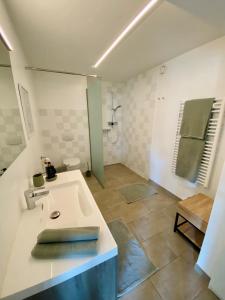 a white bathroom with a sink and a shower at Wachaulodge in Weissenkirchen in der Wachau