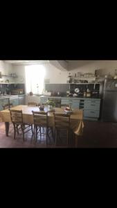 a kitchen with a table and some chairs and a table and a kitchen at L’Hourcadine in Le Pin