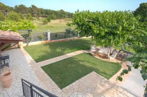 d'un jardin avec des chaises, un arbre et une pelouse. dans l'établissement Stancia Rosa - Apartment sea view, à Poreč