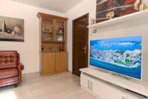 uma sala de estar com uma grande televisão de ecrã plano em Stancia Rosa - Apartment sea view em Porec