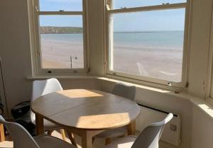 mesa y sillas en una habitación con 2 ventanas en Apartment 5, 11 The Beach - Spectacular views of the bay, en Filey 5 fotos más