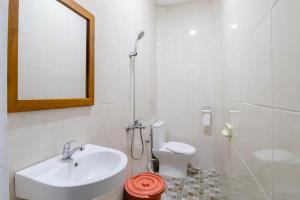 uma casa de banho com um lavatório, um WC e um espelho. em Hotel Safara Yogyakarta em Yogyakarta