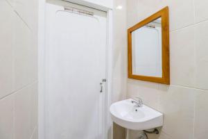 a white bathroom with a sink and a mirror at Hotel Safara Yogyakarta in Yogyakarta
