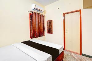 a bedroom with two beds and a window at OYO Nimalan INN in Chennai