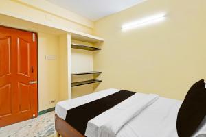 a bedroom with a bed and a red door at OYO Nimalan INN in Chennai
