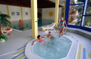 a woman and two children in a swimming pool at Studio Champfer in St. Moritz