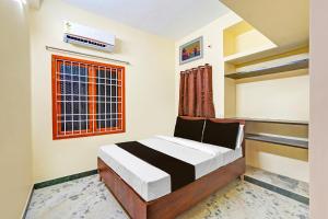a bedroom with a bed and a window at OYO Nimalan INN in Chennai