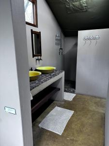 une salle de bains avec deux lavabos jaunes sur un comptoir dans l'établissement Mount Marula Game Lodge - Tambotie, à Kwarriekraal