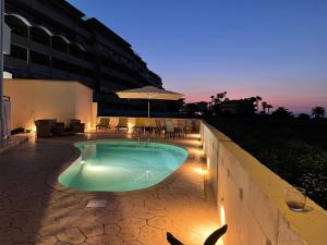 a swimming pool with lights and a building at White & Blue Beachfront Luxury Villa in Ialysos