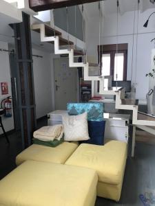 een woonkamer met een gele bank en een trap bij Loft Adrimar in Santoña